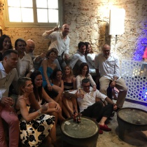 Asistentes sentados junto a la mesa del DJ durante un evento corporativo